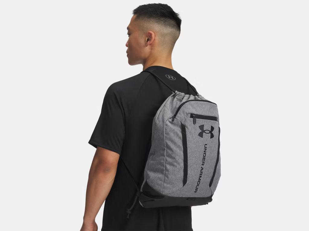 Sac à cordons UA Hustle  - Under Armour gris clair avec logo noir, porté sur mannequin, vue de dos en orientation paysage