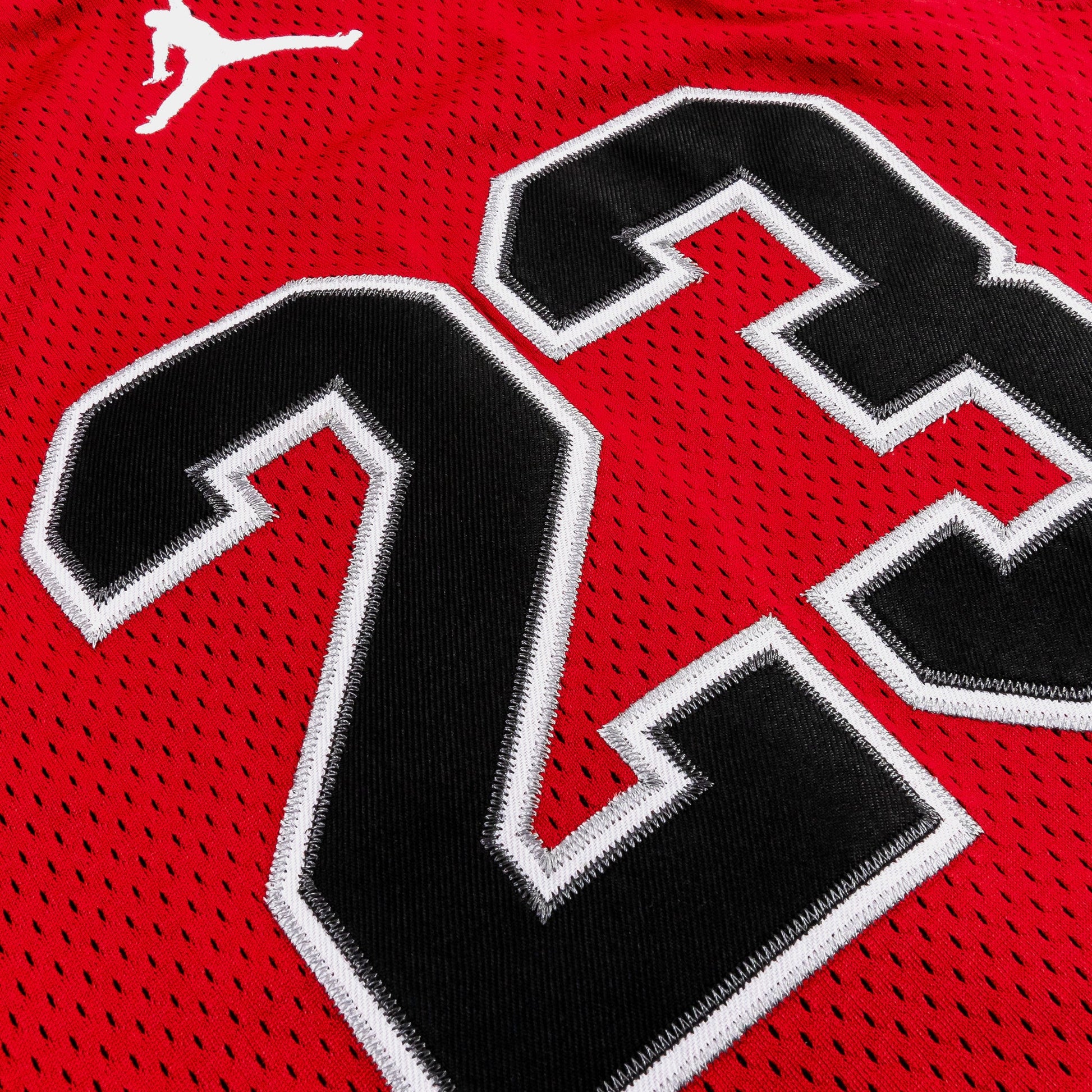 Détail du tissu en polyester rouge avec numéro noir et blanc, camisole - Jordan, vue en gros plan.