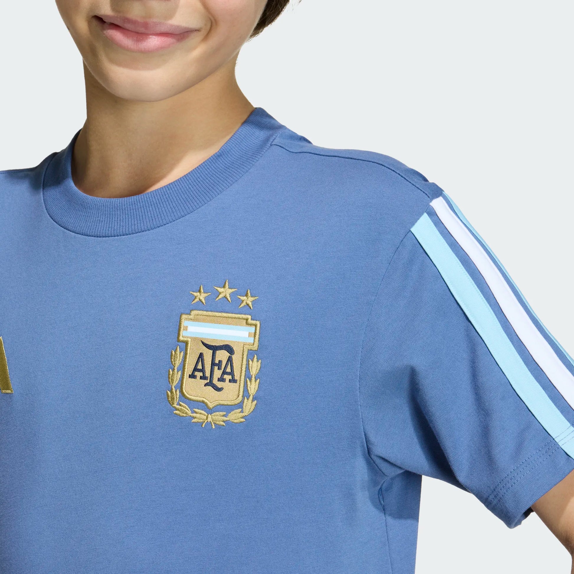 T-Shirt Argentina - Adidas bleu ciel avec logo AFA doré, rayures blanches et bleues manches courtes, coton, enfant, vue de détail face