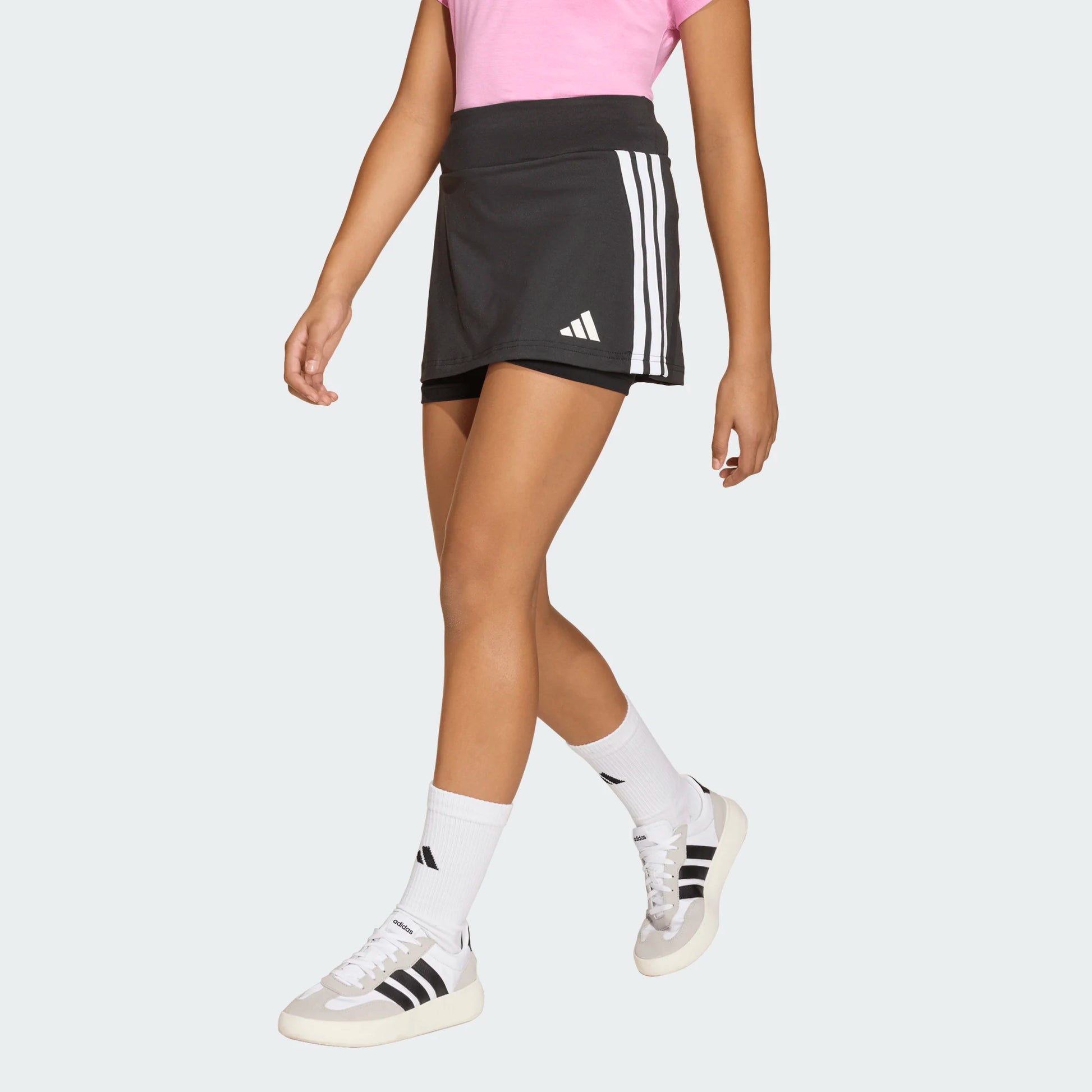 Jupe Short - Adidas noire avec bandes blanches latérales et logo, tissu léger, pour fille, vue de profil jambes.