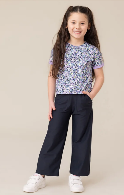 T-Shirt athlétique - Nanö à manches courtes avec motif floral violet, blanc et vert, porté par une enfant, vue de face.