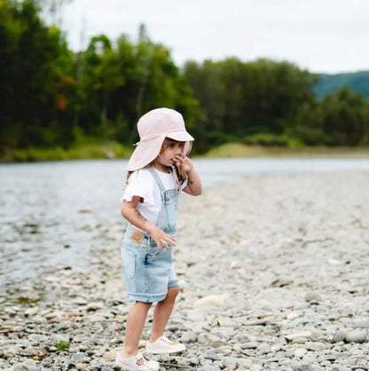Chapeau U.V - Calikids rose clair, tissu nylon et spandex, pour fille, porté de profil sur enfant debout au bord d’un ruisseau
