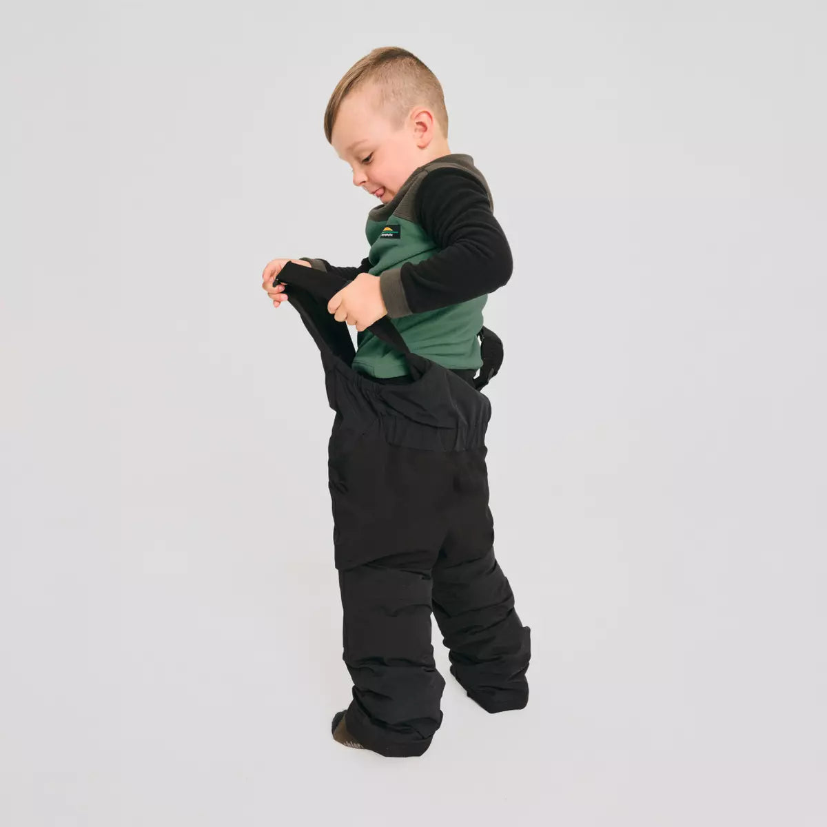 Habit de neige - Chlorophylle pantalon noir avec bretelles et haut vert foncé à manches longues, garçon, vue de profil côté dos