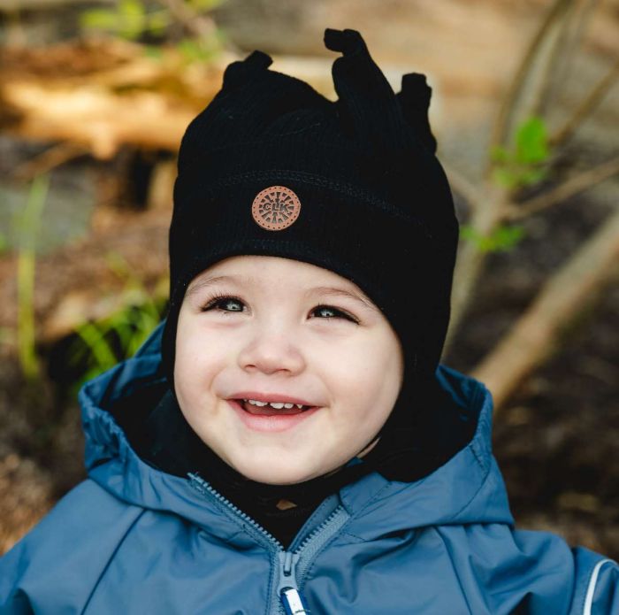 Tuque Mi-Saison - Calikids noire à pointes, portée par un jeune enfant en manteau bleu, vue de face en extérieur