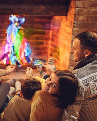 Flammes Colorées - Go Fire multicolores dans un feu de cheminée, famille en pull tricoté, vue de dos et profil côté droit