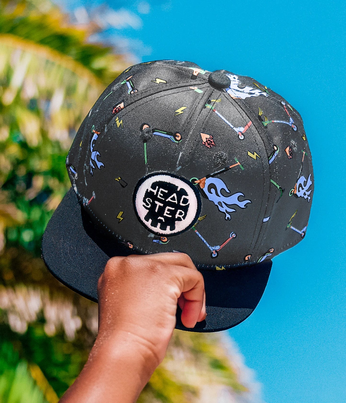 Casquette - Headtser Kids noire avec motifs colorés graphiques, logo rond blanc et noir, pour enfant, vue de face portée main