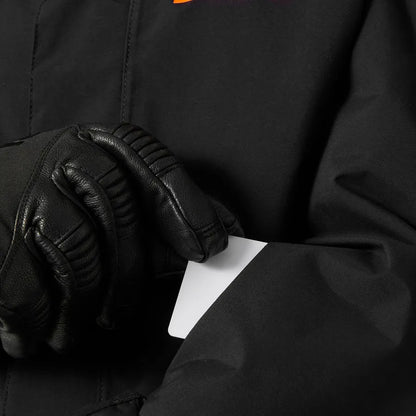 Manteau d'hiver Level Ski - Helly Hansen noir, détail poche pour forfait de ski, porté par mannequin adulte, gant noir visible