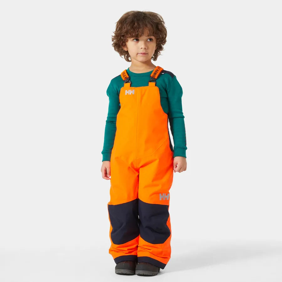 Salopette de neige - Helly Hansen orange fluo et noire, bretelles réglables, tissu imperméable, garçon, vue de face.