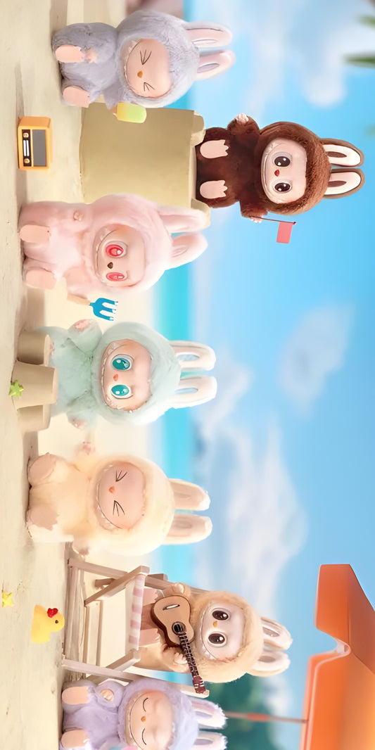 Serviette microfibre - Labubu beige posée sur sable avec jouets et peluches lapin colorés, vue de face en extérieur plage