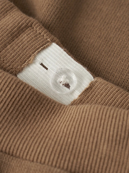 Pantalon - Name It marron en coton biologique détail bouton transparent et tissu côtelé, pour garçon, vue gros plan.