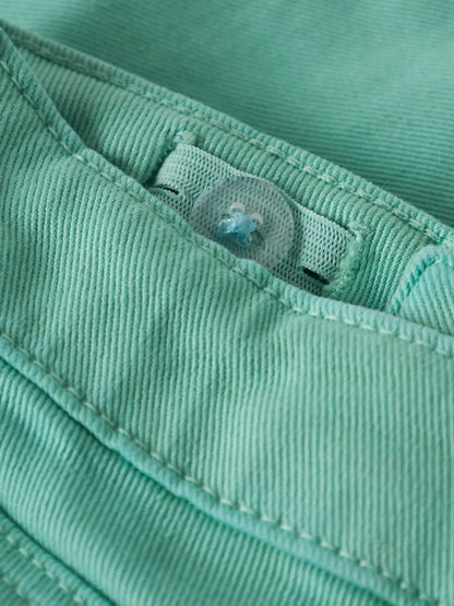 Détail bouton transparent sur tissu vert menthe en coton, Short - Name It, vue rapprochée sur couture et bouton.