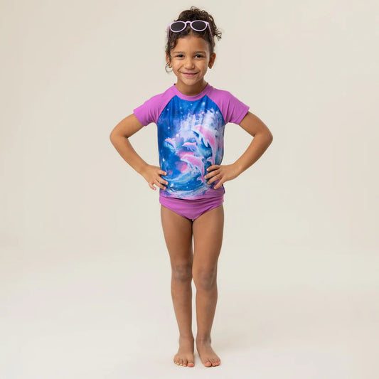 Maillot de bain - Nanö violet à manches courtes raglan avec imprimé dauphins sur fond bleu, pour fille, vue de face.