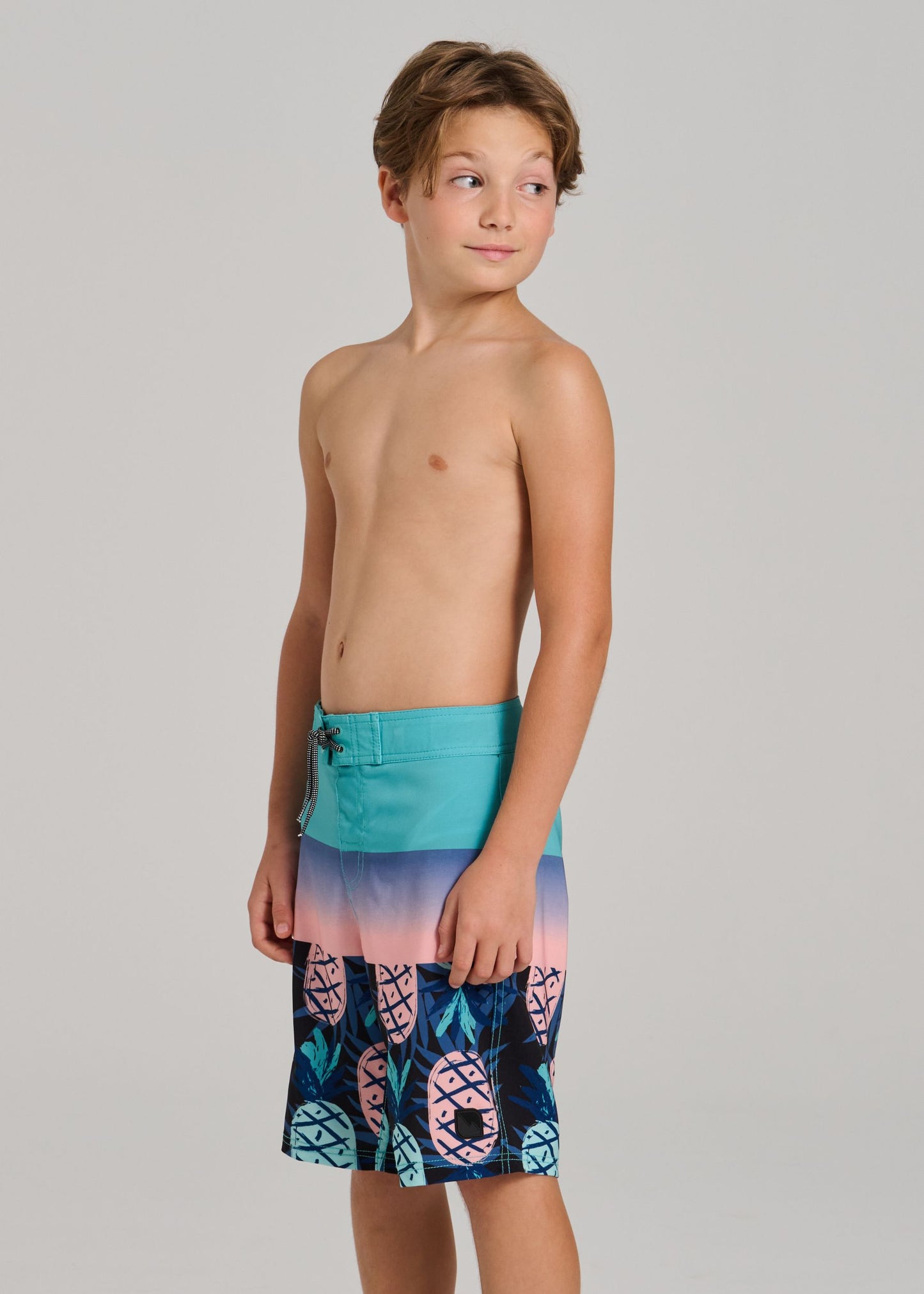 Maillot de bain - Northcoast bleu et rose dégradé à motifs ananas, culotte filets ajustable, garçon, vue de côté sur mannequin.