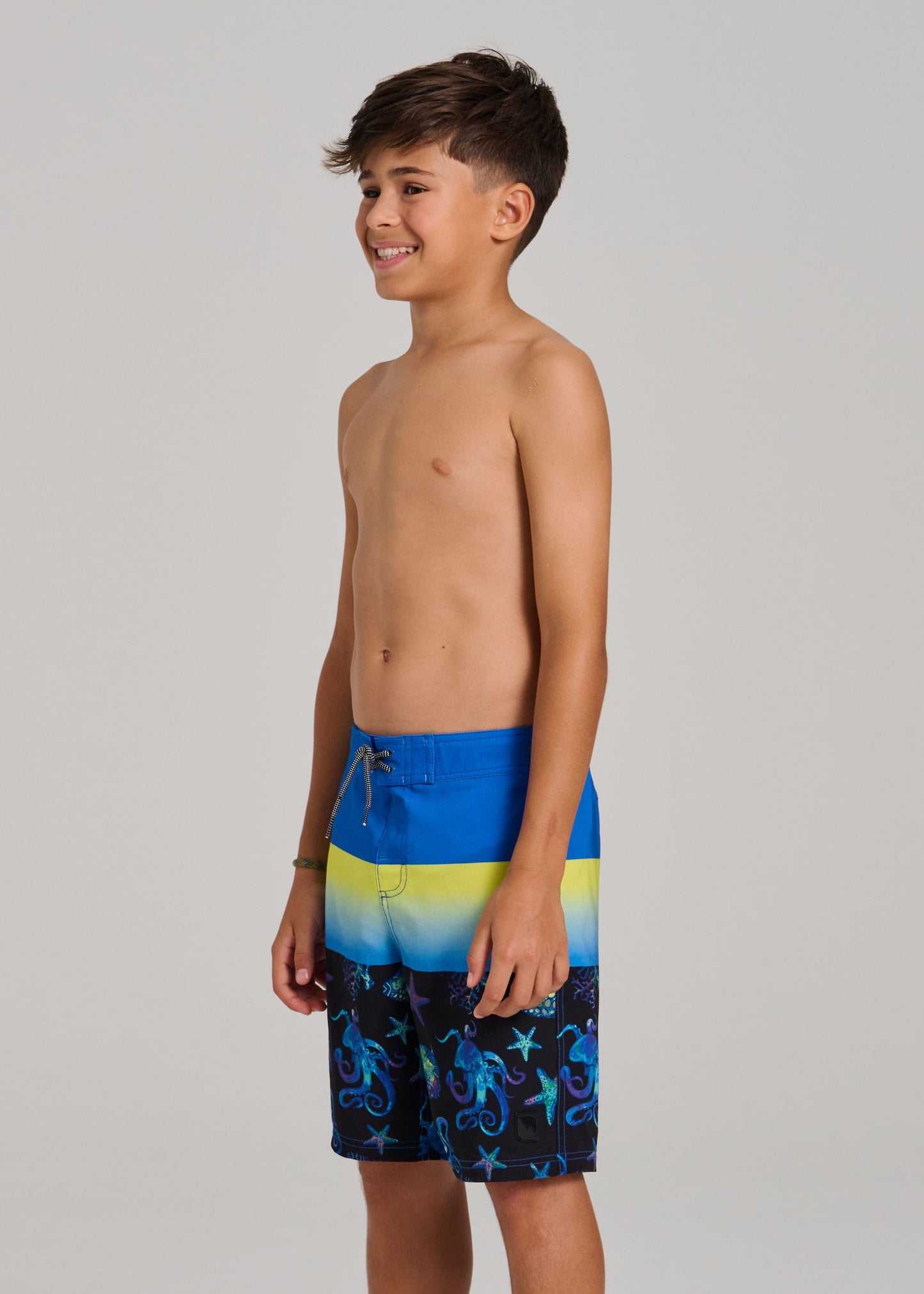 Maillot de bain - Northcoast culotte filet ajustable bleu jaune noir avec motifs marins, garçon, vue de profil porté sur mannequin.