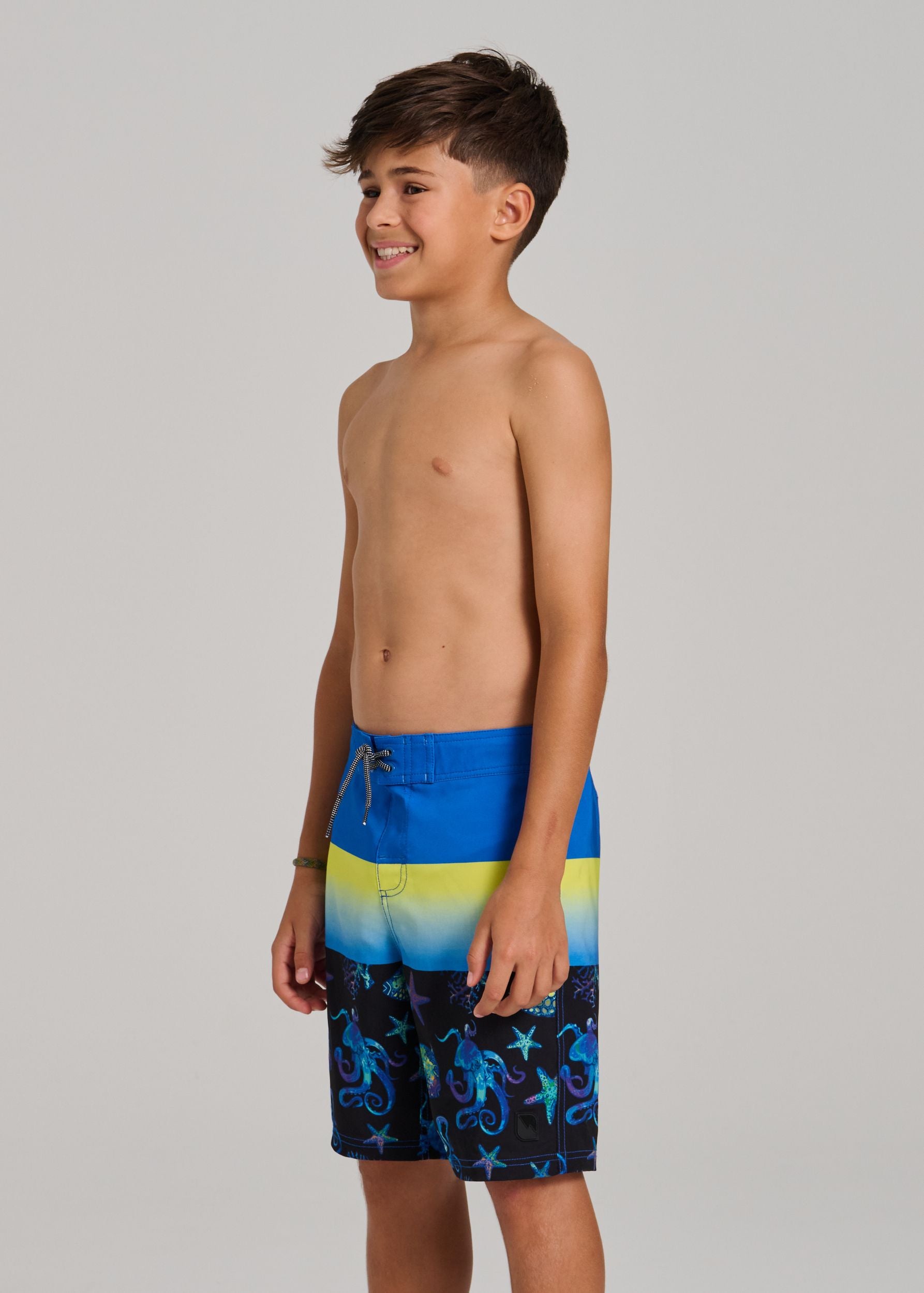 Maillot de bain - Northcoast culotte filet ajustable bleu jaune noir avec motifs marins, garçon, vue de profil porté sur mannequin.