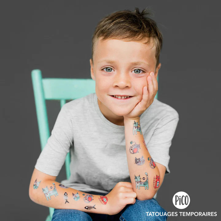 Enfant garçon souriant portant des tatouages temporaires colorés Pico Tatoo - Bibi le chat gris, vue de face bras visible