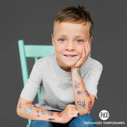 Enfant garçon souriant portant des tatouages temporaires colorés Pico Tatoo - Bibi le chat gris, vue de face bras visible