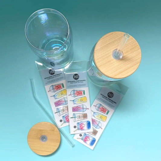 Pico Tatoo - Les breuvages rafraîchissants tatouages temporaires colorés visibles sur fond bleu, vue de dessus avec accessoires de verre.
