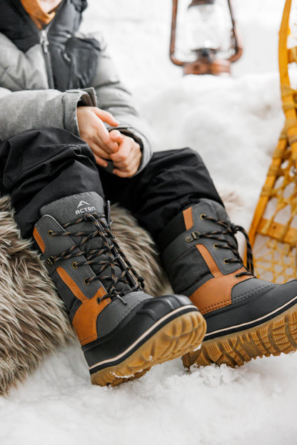 Bottes d'hiver Electro - Acton noires et brunes à lacets avec semelles crantées portées dans la neige