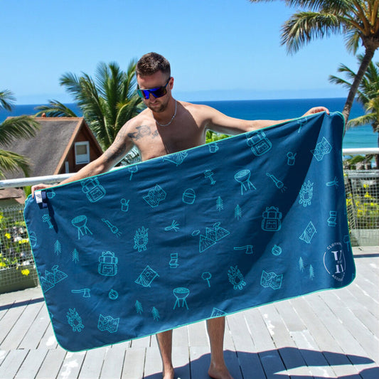 Serviette de plage - Libre comme l’air bleu marine à motifs camping verts, microfibre, portée par homme, vue de face extérieure.