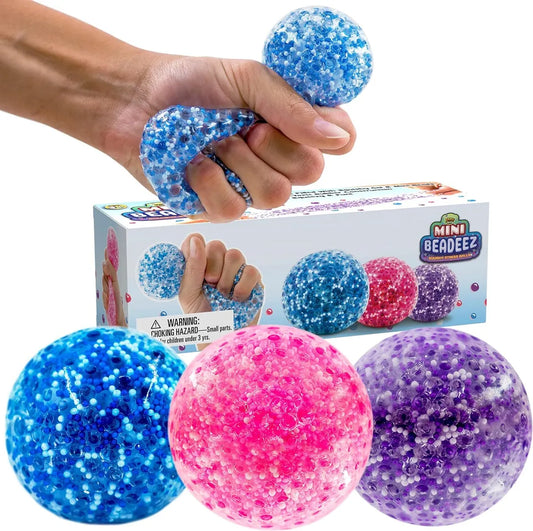 Crunch Squeeze Ball - Jouet Sensoriel boules bleue, rose et violette en gel transparent avec billes, pour enfant, vue détail et usage main.