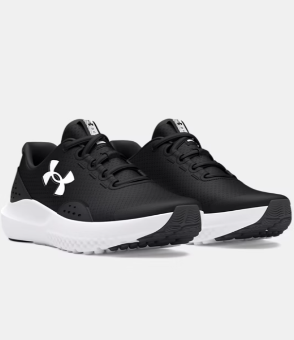 Espadrilles UA Surge 4 - Under Armour noires et blanches, tige filet légère, semelle épaisse, style sport pour enfant, vue de trois quarts face.