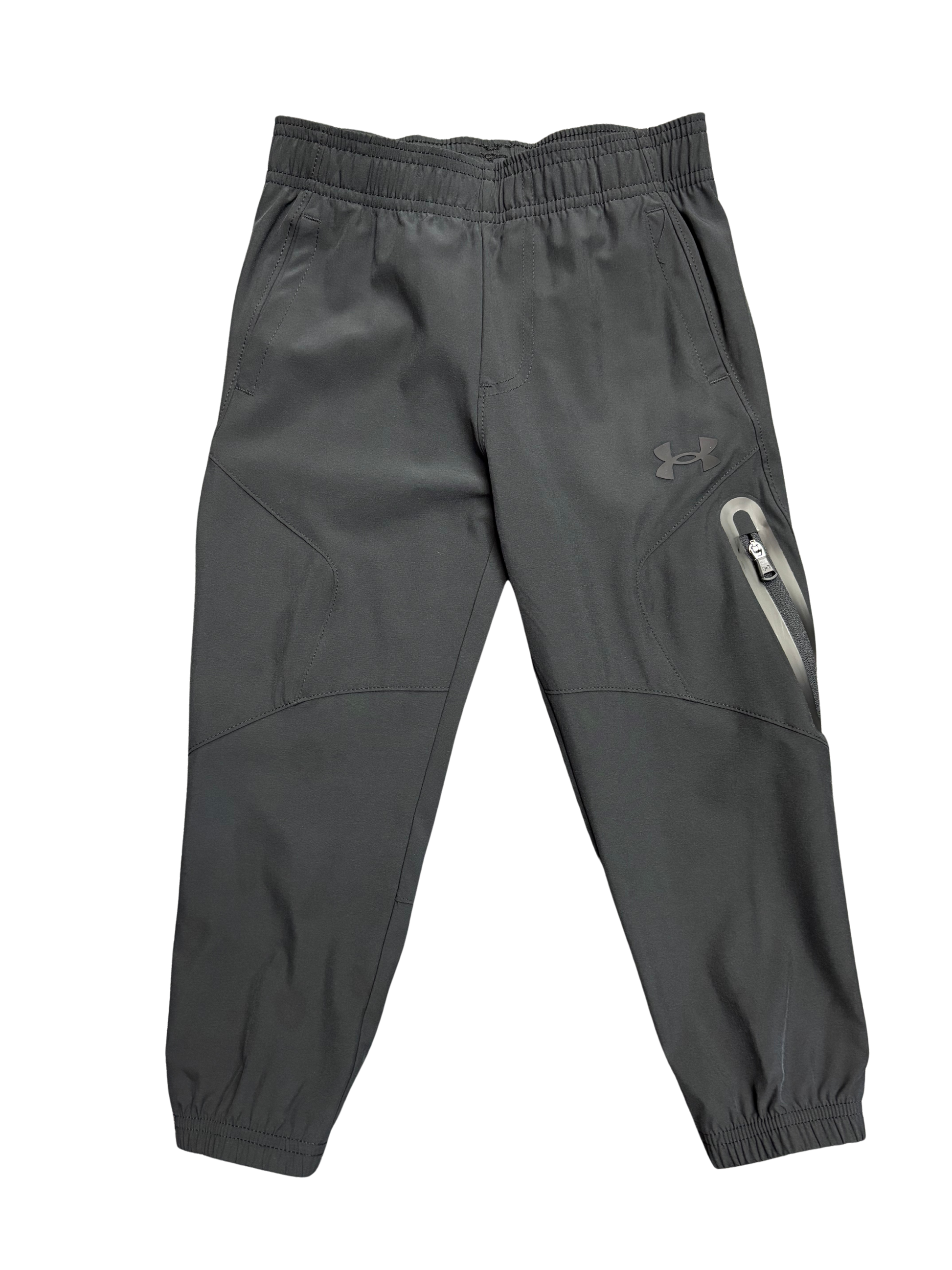 Pantalon - Under Armour gris foncé en tissu technique avec poches zippées, style sport pour garçon, vue de face.