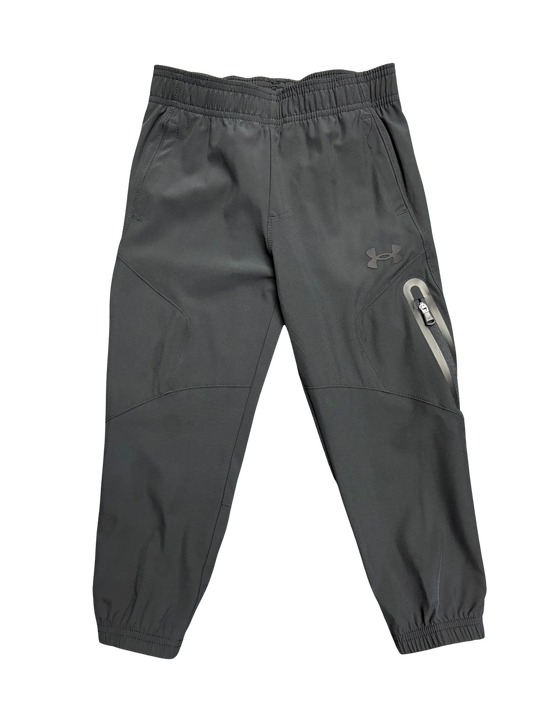 Pantalon - Under Armour gris foncé en tissu technique avec poches zippées, style sport pour garçon, vue de face.