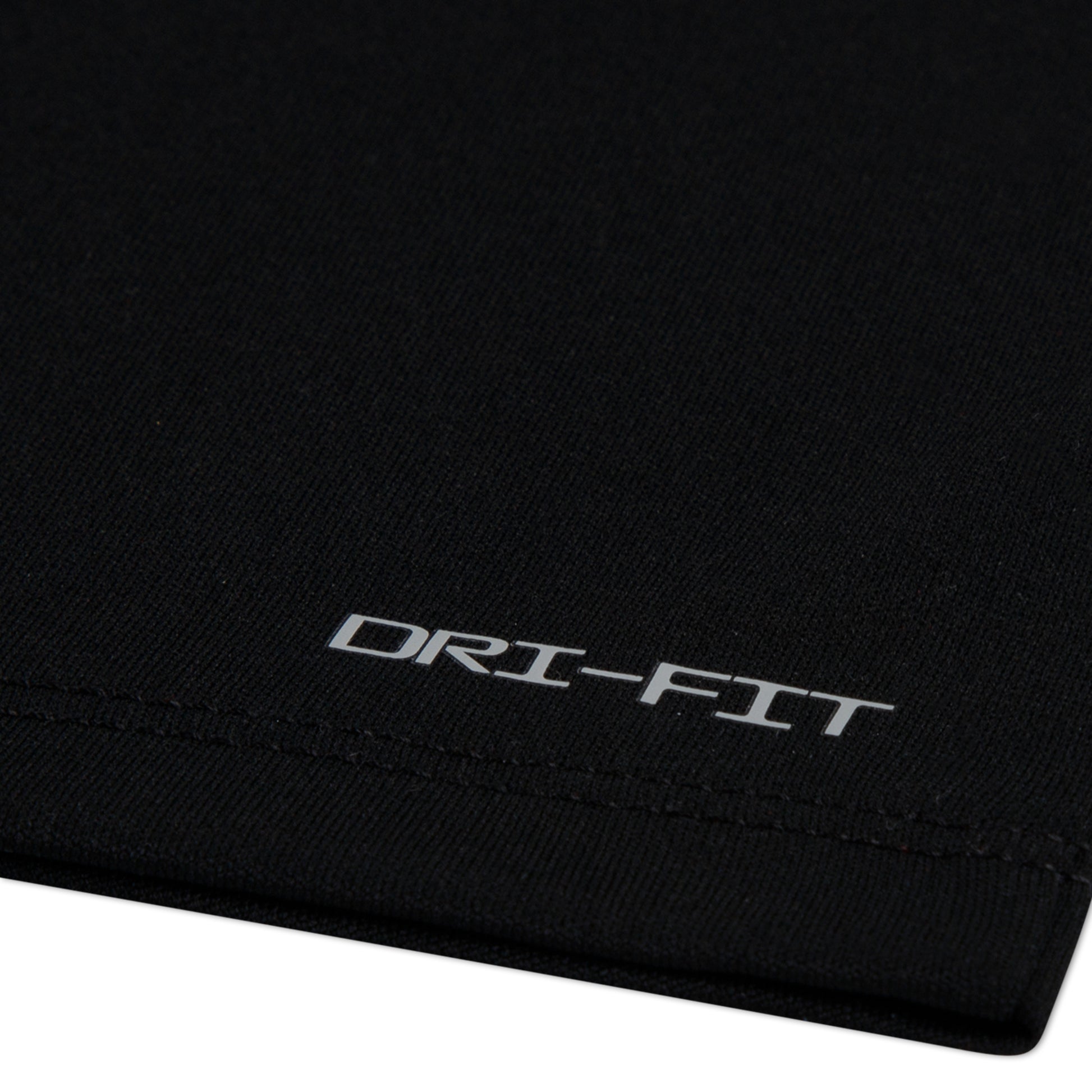 Détail de tissu noir en polyester avec inscription Dri-Fit, T-Shirt - Nike, vue rapprochée du matériau technique.