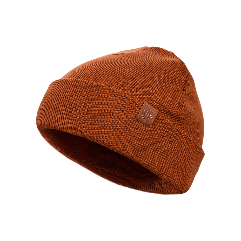 Tuque d'hiver - Kombi en tricot marron rouille avec petit écusson en cuir sur le côté, vue de trois quarts.