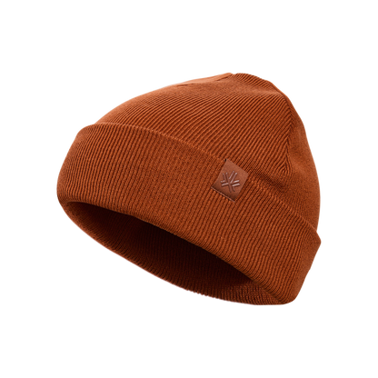 Tuque d'hiver - Kombi en tricot marron rouille avec petit écusson en cuir sur le côté, vue de trois quarts.