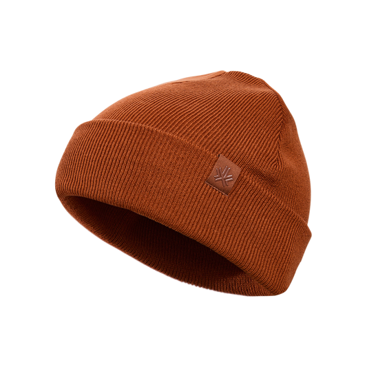 Tuque d'hiver - Kombi en tricot marron rouille avec petit écusson en cuir sur le côté, vue de trois quarts.