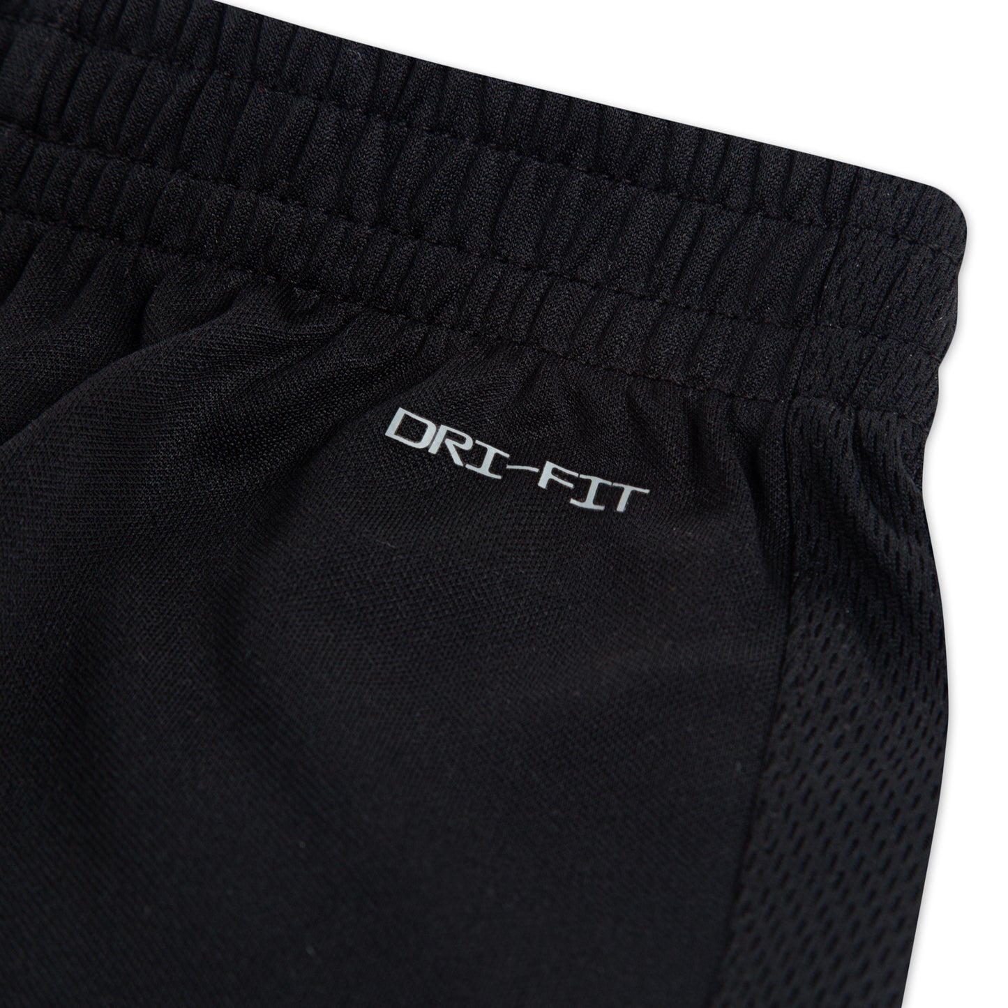 Short - Nike noir en polyester avec taille élastique et logo Dri-Fit blanc, détail textile respirant vue rapprochée.