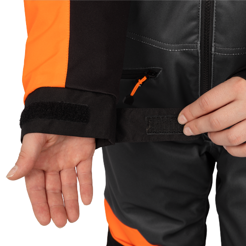 Habit de neige 1 pièce - FXR noir et orange pour enfant avec poignets et taille ajustables en tissu technique en gros plan