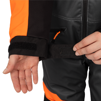 Habit de neige 1 pièce - FXR noir et orange pour enfant avec poignets et taille ajustables en tissu technique en gros plan