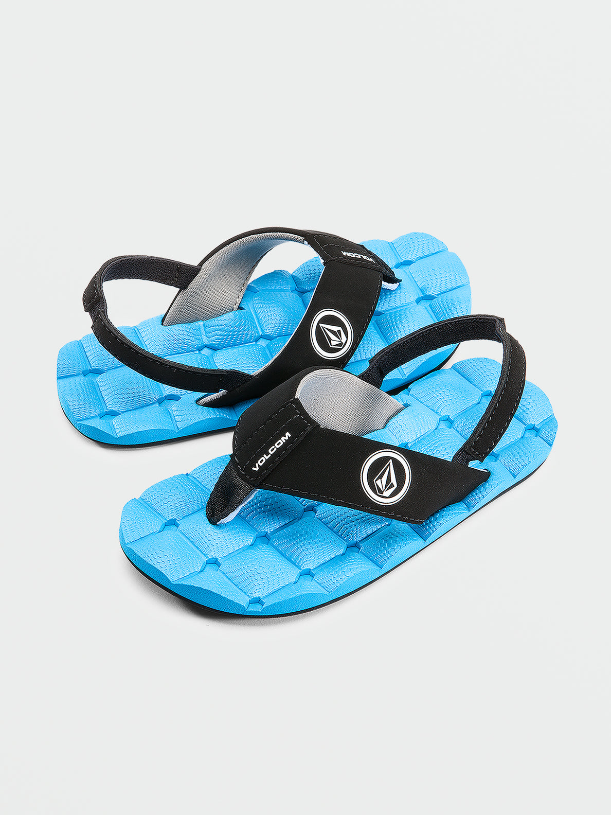 Sandales - Volcom garçon avec semelle bleue texturée et brides noires, style gougounnes, vue de côté et dessus.