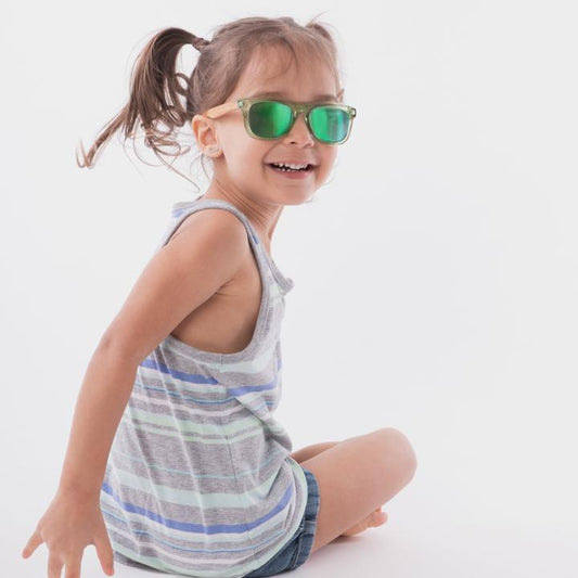 Lunettes de soleil - Lox Lion vertes avec branches en bambou portées par enfant fille, vue de côté assise souriante