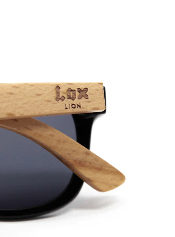 Lunettes de soleil - Lox Lion branches en bambou clair avec logo gravé, verres noirs polarisés, détail de la monture côté droit.