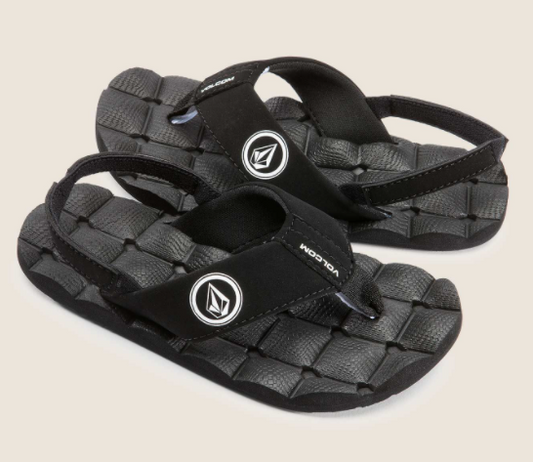 Sandales - Volcom noires avec bande élastique arrière, semelle texturée, style sport, vue en plongée angle latéral.